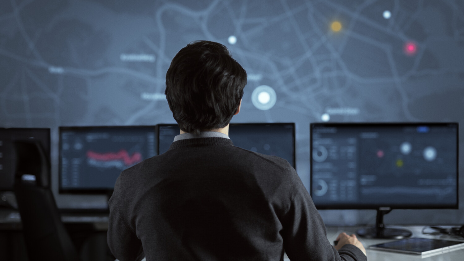 Man looking at several screens